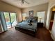 Comfortable bedroom with ceiling fan, sliding glass doors leading to outdoor lounge area and en-suite bathroom at 446 Summer Place Loop, Clermont, FL 34714