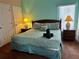 Relaxing bedroom featuring lamps, a closet, and a queen bed with stylish linens at 446 Summer Place Loop, Clermont, FL 34714