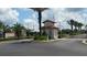 Secure gated community entrance featuring a guard house and lush landscaping at 446 Summer Place Loop, Clermont, FL 34714