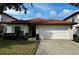 Charming single Gathering home featuring a red tile roof, two-car garage, and manicured lawn at 446 Summer Place Loop, Clermont, FL 34714