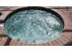 Close up of a bubbling in-ground hot tub with brick border at 446 Summer Place Loop, Clermont, FL 34714