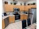 Well-equipped kitchen with stainless steel appliances, light wood cabinetry, and tiled flooring at 446 Summer Place Loop, Clermont, FL 34714