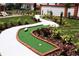A winding mini golf course amid lush landscaping offers a fun outdoor recreational activity for residents at 446 Summer Place Loop, Clermont, FL 34714