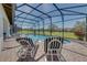 Inviting screened-in pool area with striped lounge chairs and beautiful backyard views at 446 Summer Place Loop, Clermont, FL 34714