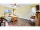 Bright bedroom with hardwood floors, two windows, and a neutral yellow color scheme at 4674 Hall Rd, Orlando, FL 32817