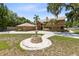 Stunning home exterior with a circular driveway, fountain, and lush landscaping at 4674 Hall Rd, Orlando, FL 32817