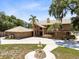 Elegant home featuring lush landscaping and a circular driveway with a fountain at 4674 Hall Rd, Orlando, FL 32817