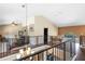 Upstairs landing featuring hardwood floors, decorative railing, and comfortable seating area with natural light from the window at 4674 Hall Rd, Orlando, FL 32817