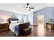 Comfortable main bedroom with hardwood floors, ceiling fan, sitting area, and entry to the main bathroom at 4674 Hall Rd, Orlando, FL 32817