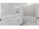 Clean bathroom with white vanity, countertop, and tub with tiled surround at 499 Silver Palm Dr, Haines City, FL 33844
