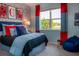 Comfortable bedroom with blue walls, gaming-themed art, and a window with natural light. A fun space! at 499 Silver Palm Dr, Haines City, FL 33844