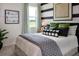 Stylish bedroom with striped accent wall, a comfortable bed, and an eye-catching art, creating a cozy retreat at 499 Silver Palm Dr, Haines City, FL 33844