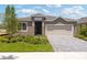 Charming single-Gathering home with manicured lawn and a two-car garage on a sunny day at 499 Silver Palm Dr, Haines City, FL 33844