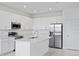 Modern kitchen features white cabinetry, stainless steel appliances, and a center island at 499 Silver Palm Dr, Haines City, FL 33844