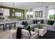 Open-concept living room with a large sofa, a dining area, and a modern kitchen, perfect for entertaining guests at 499 Silver Palm Dr, Haines City, FL 33844