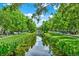Symmetrical view of a waterway reflecting the sky, bordered by green lawns and trees in a residential community at 501 Water St # 501, Celebration, FL 34747
