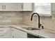 Close up of the kitchen sink with granite countertops, tile backsplash, and modern fixtures at 501 Water St # 501, Celebration, FL 34747
