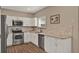 Well-equipped kitchen featuring stainless steel appliances, white cabinetry, and modern finishes at 501 Water St # 501, Celebration, FL 34747