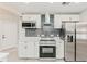 Modern kitchen with stainless steel appliances, white cabinets, and a subway tile backsplash at 5037 Water Wheel Ct, Ocoee, FL 34761