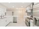 Modern kitchen featuring white cabinets, stainless steel appliances, and a stylish backsplash at 5037 Water Wheel Ct, Ocoee, FL 34761