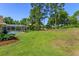 Lush green backyard featuring a screened-in pool and mature trees for privacy at 513 N Pine Meadow Dr, Debary, FL 32713