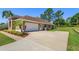 Side view of the home showing a spacious driveway leading to the 2-car garage at 513 N Pine Meadow Dr, Debary, FL 32713