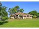 Beautiful one-story home featuring a well-manicured lawn, lush landscaping, and a neutral-colored exterior at 513 N Pine Meadow Dr, Debary, FL 32713