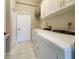 Bright laundry room features tile flooring, white cabinets and modern appliances at 513 N Pine Meadow Dr, Debary, FL 32713