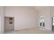 Vaulted living room with carpet, tile flooring, built-in shelving, and double doors to the lanai at 513 N Pine Meadow Dr, Debary, FL 32713