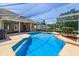 A screen enclosure surrounds a backyard pool with a concrete deck, landscaping, and outdoor seating at 513 N Pine Meadow Dr, Debary, FL 32713