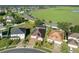 Aerial view of home with a screened-in pool, solar panels, and view of a green field at 5273 Sunset Canyon Dr, Kissimmee, FL 34758