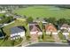 Aerial view of community, home with a screened-in pool, solar panels, and view of a green field at 5273 Sunset Canyon Dr, Kissimmee, FL 34758