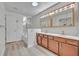 Bright bathroom with double sink vanity, framed mirrors with lighting, and a tub at 5273 Sunset Canyon Dr, Kissimmee, FL 34758