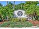 Beautiful community sign surrounded by palm trees and lush landscaping at the entrance of the property at 5273 Sunset Canyon Dr, Kissimmee, FL 34758