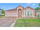 Charming single-story home with a well-manicured lawn and a two-car garage on a sunny day at 5273 Sunset Canyon Dr, Kissimmee, FL 34758