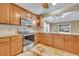 Kitchen with stainless steel appliances, wood cabinets, granite counters and an eating area at 5273 Sunset Canyon Dr, Kissimmee, FL 34758