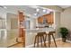 Modern kitchen featuring wood cabinets, breakfast bar, granite countertops, and stainless steel appliances at 5273 Sunset Canyon Dr, Kissimmee, FL 34758