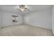 Spacious main bedroom featuring a ceiling fan, a window, and neutral carpeting at 5273 Sunset Canyon Dr, Kissimmee, FL 34758