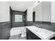 Modern bathroom with gray tiled walls, sleek vanity, and a tub-shower combo, complete with fixtures at 5513 Riordan Way, Orlando, FL 32808