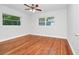Bedroom with hardwood floors, a ceiling fan, and two windows that provide natural light and ventilation at 5513 Riordan Way, Orlando, FL 32808
