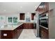 Spacious kitchen with dark wood cabinets, stainless steel appliances, and granite countertops at 5513 Riordan Way, Orlando, FL 32808