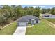 An aerial shot reveals a well-situated home with a two-car garage, pristine lawn, and lush greenery in the backdrop at 586 Marion Oaks Trl, Ocala, FL 34473