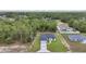 Overhead view of home with fresh green lawn, a two-car garage, and a long driveway leading to the street at 586 Marion Oaks Trl, Ocala, FL 34473