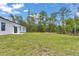 Large grassy backyard featuring green grass and surrounding mature trees for privacy and space at 586 Marion Oaks Trl, Ocala, FL 34473