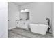 Modern bathroom featuring a soaking tub, dual sink vanity, and walk-in shower at 586 Marion Oaks Trl, Ocala, FL 34473
