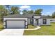 Charming single-story home with a crisp white exterior, black trim, a well-manicured lawn, and a two-car garage at 586 Marion Oaks Trl, Ocala, FL 34473