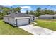 Side view of a modern white house with a two-car garage, long driveway, and manicured lawn at 586 Marion Oaks Trl, Ocala, FL 34473