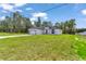 A wide shot showcasing the home's well-maintained lawn and inviting facade against a backdrop of lush trees at 586 Marion Oaks Trl, Ocala, FL 34473