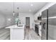 Kitchen features white cabinets, stainless steel appliances, island with sink, and pendant lighting at 586 Marion Oaks Trl, Ocala, FL 34473