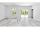 A light, bright living room with wood-style flooring, a large window, and sliding glass doors at 586 Marion Oaks Trl, Ocala, FL 34473